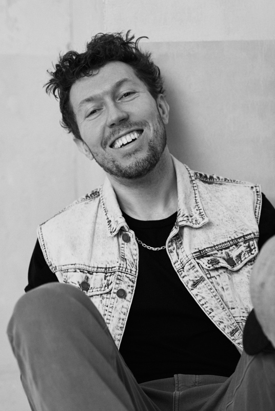 Ivan Kurkin smiling, in a black-and-white portrait.